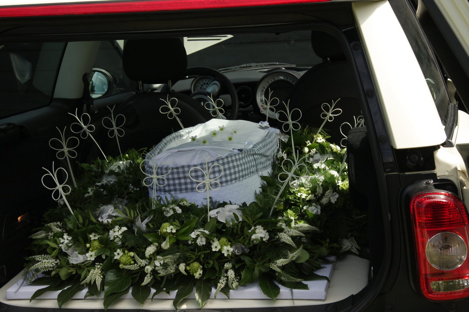 Een babymandje omringd door witte bloemen in de Minirouwauto