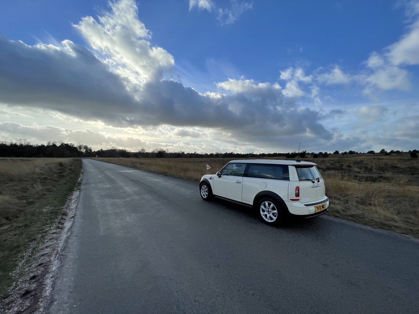 De Minirouwauto onderweg over een smalle weg door de hei